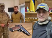 Николай Тищенко в балаклаве получает наградное оружие