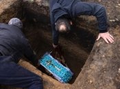 Маленьку труну опускають у могилу