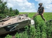 Боец ВСУ у подбитой российской боевой машины