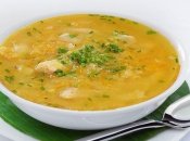 Аппетитная тарелка горохового супа с мясом, зеленью и гренками.