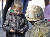 Хлопчик тримає пістолет під час дитячого фестивалю «Місто професій»