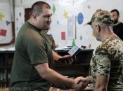 Дмитрий Лысюк (слева) вручает награду бойцу, июнь 2023 года