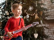 Мальчик играет на игрушечной гитаре