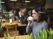 Дівчина в закладі пʼє каву