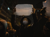 Протестующий держит чистый лист во время марша в Пекине. Воскресенье, 27 ноября 2022 г.