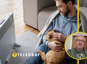 Мужчина с кошкой греется у обогревателя