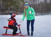 Ребенок с мамой катаются на санках