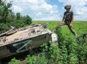 Боец ВСУ у подбитой российской боевой машины