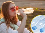 Девушка пьет из пластиковой бутылки.