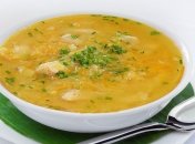 Аппетитная тарелка горохового супа с мясом, зеленью и гренками.