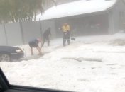 Спасатель помогает жителям расчищать подъездную дорожку.