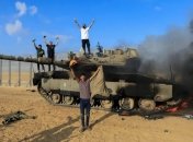 Боевики ХАМАС на фоне подбитого израильского танка