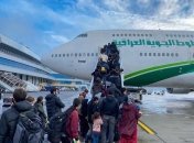 Мігранти сідають у літак