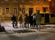 Мужчину пытаются затолкать в микроавтобус