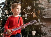 Мальчик играет на игрушечной гитаре