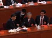 Охоронець намагається підняти за руки Ху Цзіньтао, поряд — Сі Цзіньпін