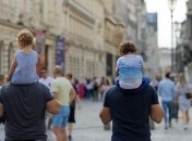 Дети сидят на плечах взрослых