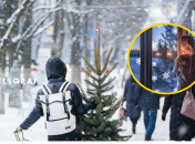 Снежная праздничная улица и девушка, что смотрит в окно