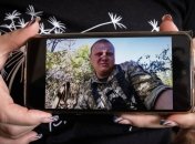 Оксана держит фото Дениса Ткача