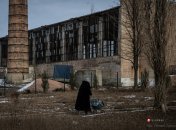 Бабуся везе воду на фоні обстріляного цеху