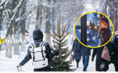 Снежная праздничная улица и девушка, что смотрит в окно