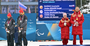 Линн Казмайер вместе со своим гидом Флорианом Бауманом отвернулись в сторону во время гимна России