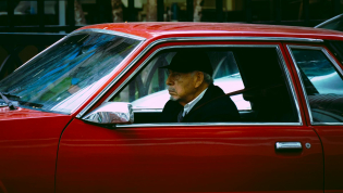 Пожилой мужчина за рулем