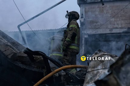 Рятувальники та пожежний рукав на згарищі Епіцентру