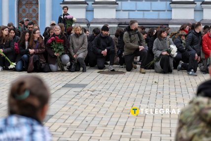 Містяни стають на коліна вздовж дороги, коли виносять тіло /Ян Доброносов, "Телеграф"