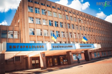 Фасад Ужгородського національного університету з двома прапорами України