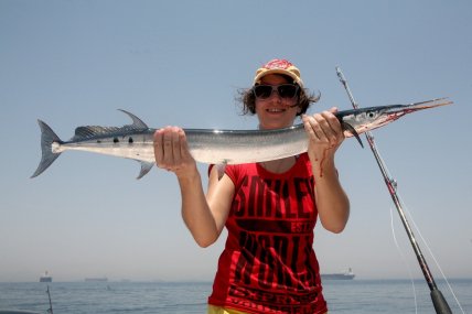 Женщина, держащая взрослый сарган.