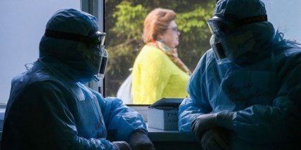 люди в защитных костюмах