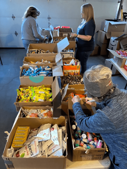 Люди збирають посилки з предметами першої потреби