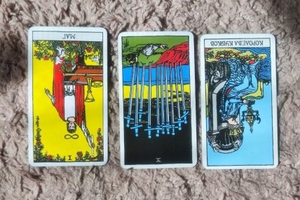Слева направо — перевернутый Маг, перевернутая Десятка мечей и перевернутая Королева Кубков