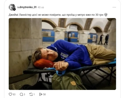 Мужчина в синей кофте и бежевых брюках лежит на раскладушке в метро