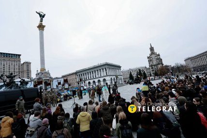 Люди стоять на колінах, коли проносять труну з тілом військового /Ян Доброносов, "Телеграф"