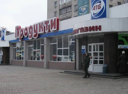 Будівля магазину з вивіскою "Продукти" та логотипом "АТБ"