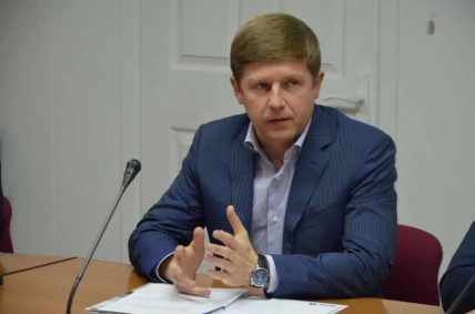 Сергій Нагорняк у синьому піджаку сидить за столом із документами біля мікрофона й жестикулює