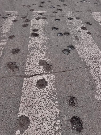 Сліди касетного боєприпасу на асфальті після обстрілу Дніпра