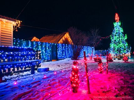 Будинок, паркан, ялинка прикрашені гірляндами