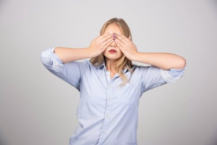 Дівчина закрила очі руками