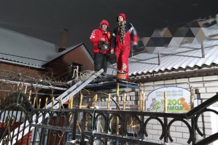 Двоє чоловіків біля даху приватного будинку