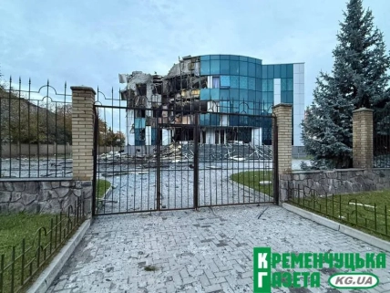 Пошкоджена скляна офісна будівля за металевою огорожею