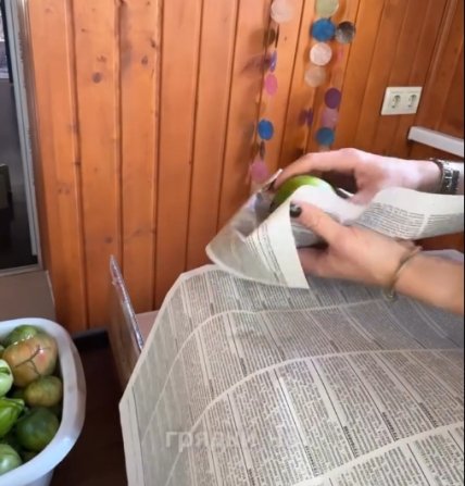 Каждый из помидоров заворачивается в газету