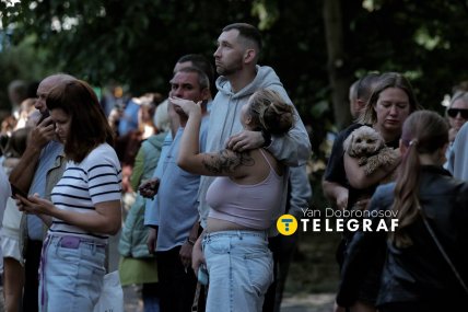 Люди спостерігають за роботою рятувальників біля будинку, в який влучив російський шахед в Києві 9.09