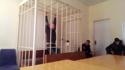 Подсудимый в клетке в зале суда