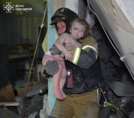 Спасател  с ребенком из дома в Одессе, куда ударил российский дрон