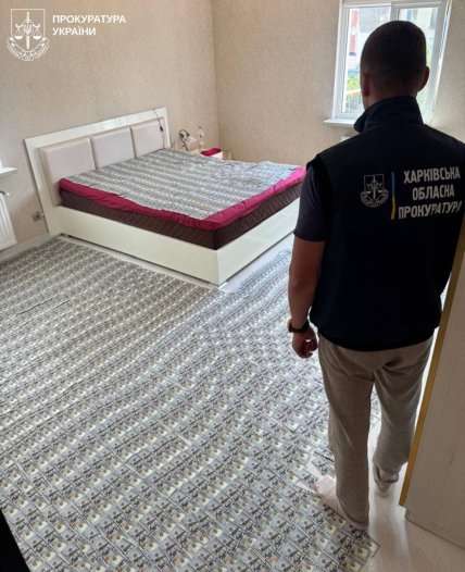 Гроші, знайдені під час обшуку, розкладені по ліжку та підлозі