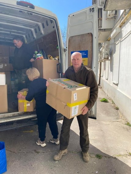 Александр держит в руках ящик з гуманитарной помощью