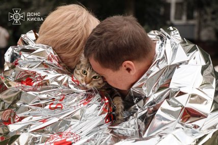Постраждалі внаслідок обстрілу Києва в ніч проти 6 липня у фольгованій ковдрі з котом